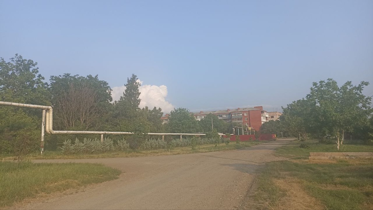 слева расположено кладбище; вдалеке виднеется дом, в котором мы живём