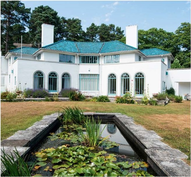 Яффл Хилл. 1929-1930. Пул. Архитектор Эдвард Мауф. Источник: Элейн Харвуд. Ар-деко Британии.  Картер (заказчик) специально выкрасил панели крыши в китайский синий цвет. Над входом изображен керамический дятел (местные жители называют его "яффл"), а пол холла украшает мозаика с изображением дома, видом на фабрику у гавани и инициалами Картера и Мауфа