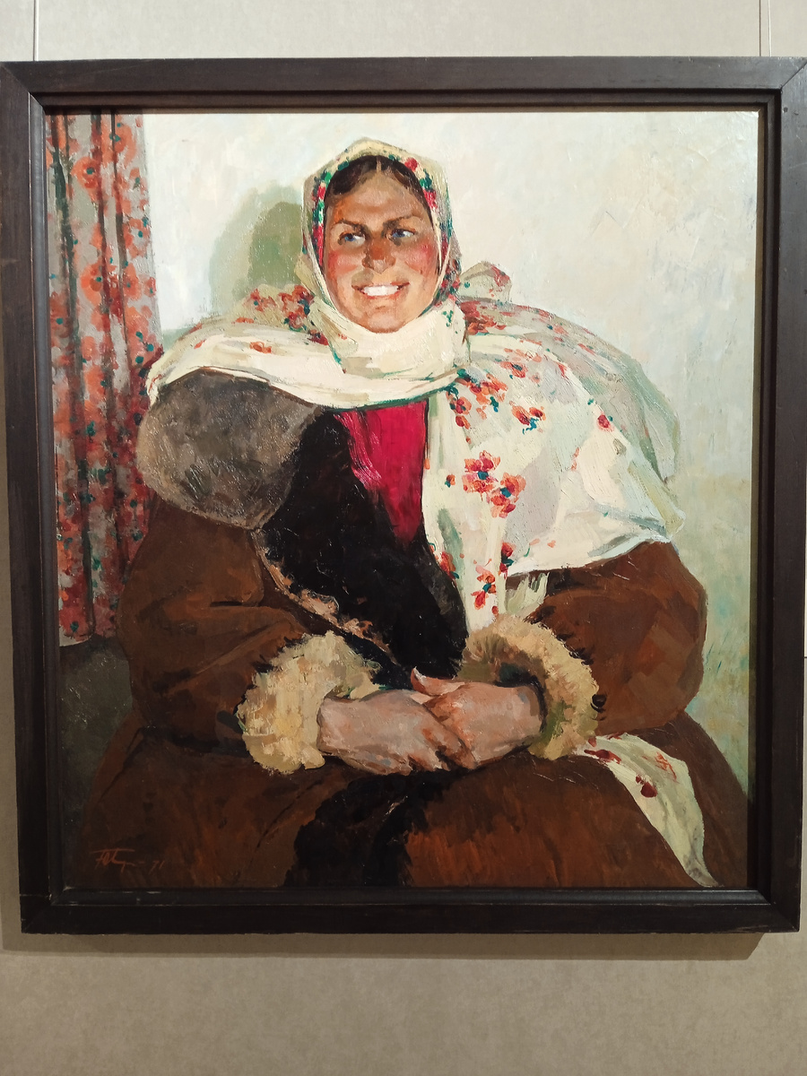 Просто картина. Сфотографировала на какой-то выставке. Женщина в тулупе, в платке, сидит улыбается. Наверное замуж удачно вышла? 