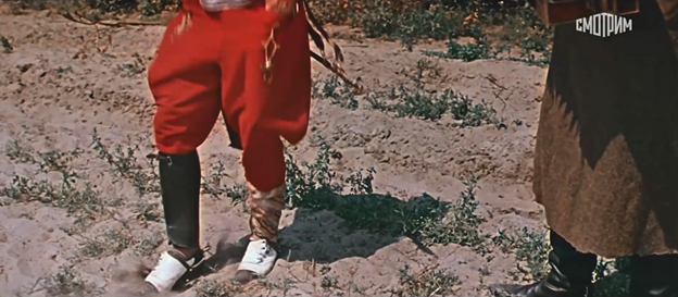 Рис. 2. Фрагмент кадра из кинофильма «Свадьба в Малиновке» (1967).
На Попандопуло надеты красные «революционные» брюки-«галифе» и модные ботиночки «со скрипом».
