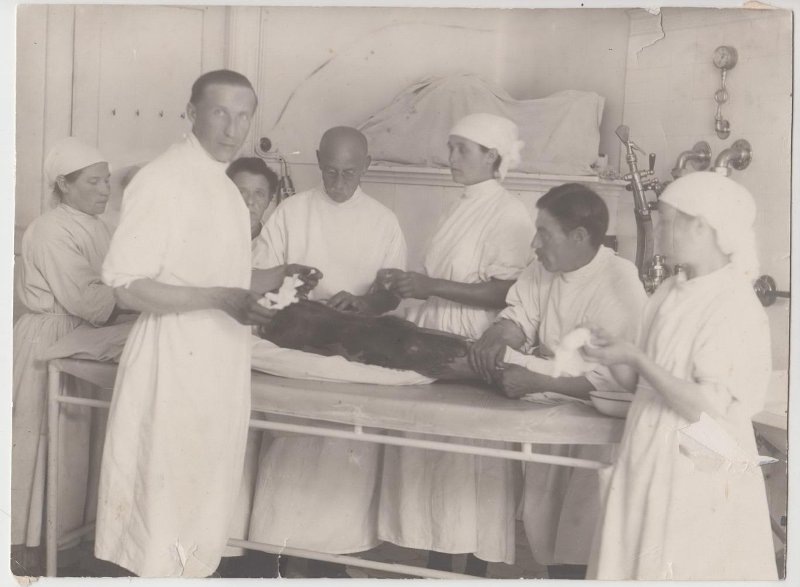 А.Г. Залога позади операционного стола в очках. 1920-1930е.
