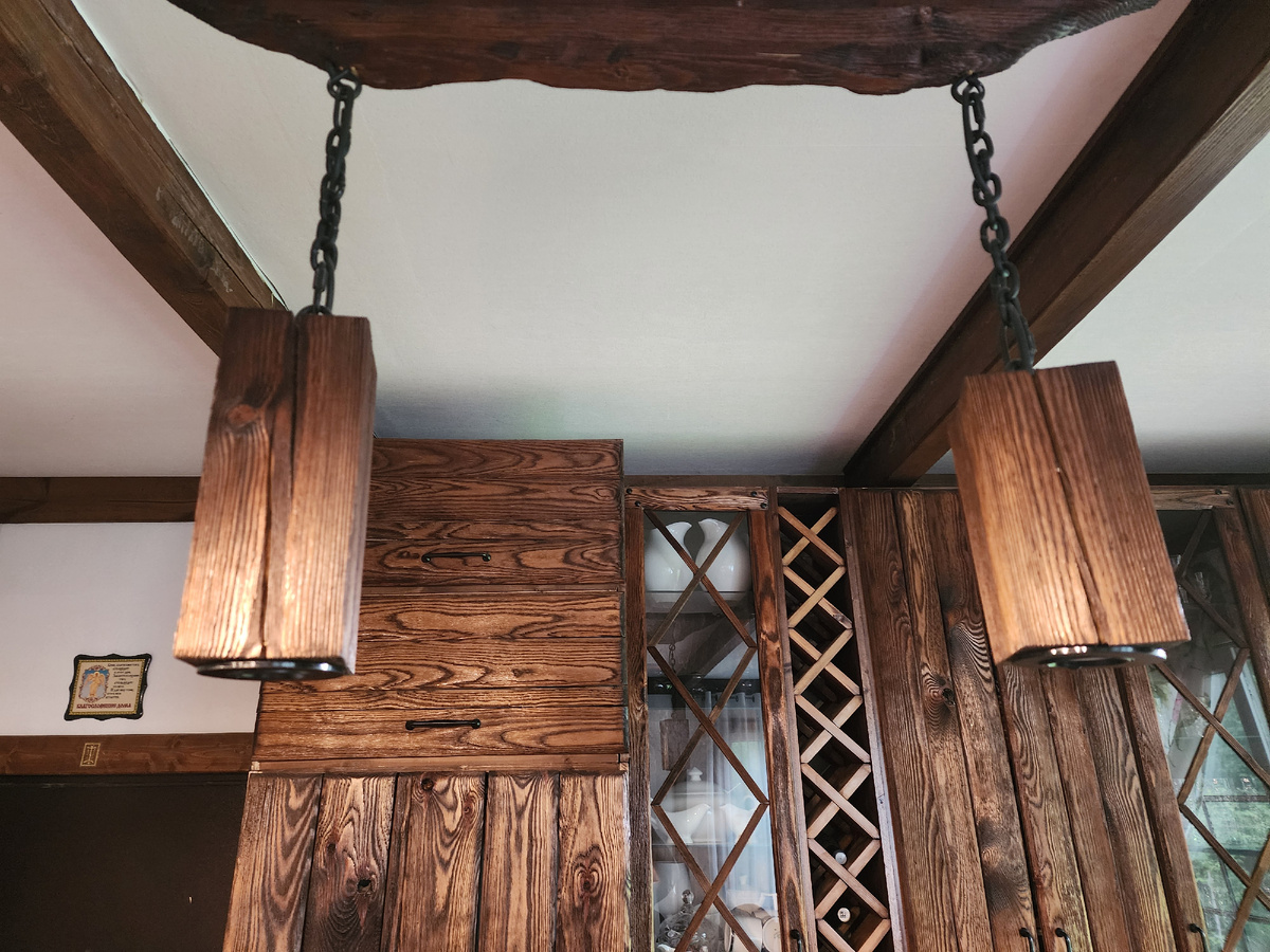 Подвесной светильник размещен между двумя потолочными балками