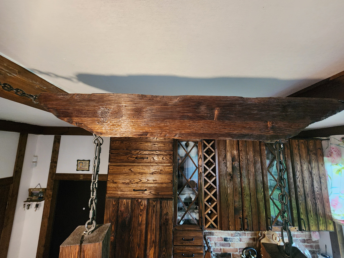 Подвесной светильник размещен между двумя потолочными балками