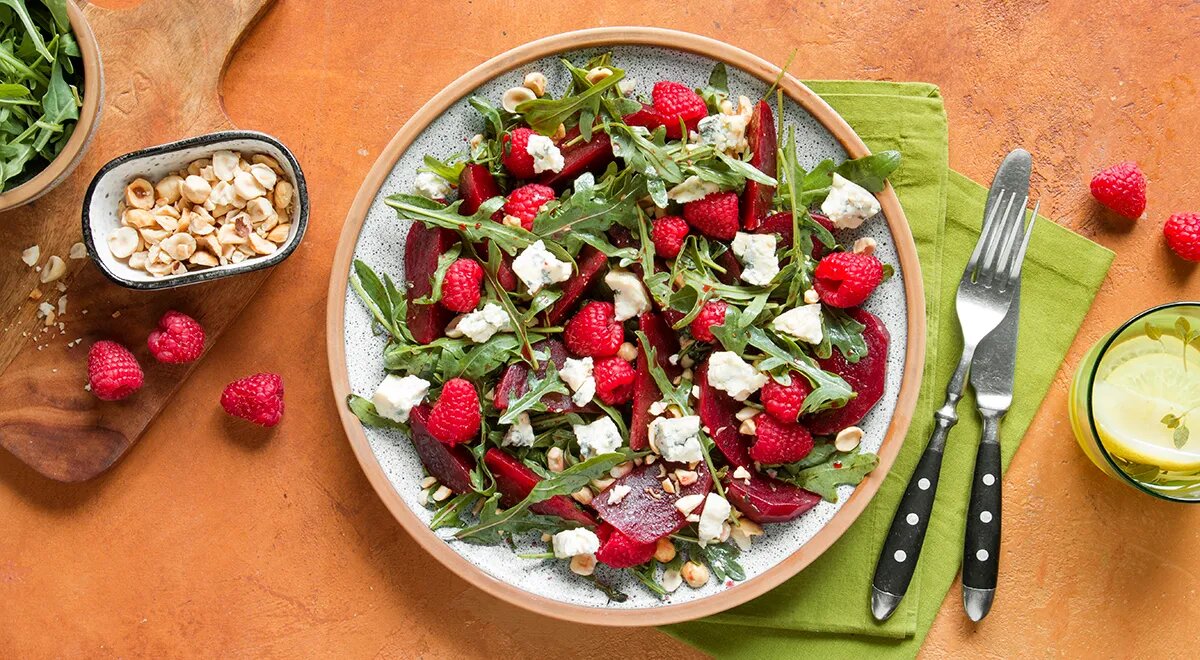 Летний салат: освежающий вкус лета в каждой ложке

Летний салат — это лёгкое и полезное блюдо, которое идеально подходит для жарких дней. В нем сочетаются свежесть сезонных овощей и фруктов, которые насыщают организм витаминами и минералами, помогают поддерживать водный баланс и дарят ощущение лёгкости. В этой статье мы расскажем, как приготовить вкусный летний салат, который станет отличным дополнением к вашему обеду.

Почему летний салат так популярен?
Летний салат — это вкусное и лёгкое блюдо, идеально подходящее для жаркого времени года. Он состоит из свежих, натуральных продуктов, которые насыщены водой и питательными веществами. Овощи, такие как помидоры, огурцы и болгарский перец, а также ягоды и зелень, помогают поддерживать водный баланс, насыщают организм витаминами и микроэлементами.

Кроме того, летний салат можно легко адаптировать под любые вкусы, добавляя или меняя ингредиенты.

Основные компоненты летнего салата
Зелень — основа салата. Руккола, латук, шпинат или смесь зелёных листьев придают свежесть и лёгкость.

Овощи. Помидоры, огурцы и болгарский перец — это основа большинства летних салатов. Они придают блюду яркость и насыщенный вкус.

Фрукты. Ягоды (клубника, малина, черника) или цитрусовые добавляют сладость и кислинку.

Орехи и сыр. Орехи (кедровые, грецкие) и лёгкие сыры (фета, моцарелла) придают салату хрустящую текстуру и насыщенность.

Заправка. Лёгкая заправка на основе оливкового масла и лимонного сока подчеркнёт вкус овощей и зелени.
Рецепт свежего летнего салата
Ингредиенты:
Листья салата (руккола, латук) — 200 г
Помидоры черри — 150 г
Огурцы — 2 штуки
Болгарский перец — 1 штука
Фета — 100 г
Оливки — 100 г
Лимон — 1 штука
Оливковое масло — 2 ст. ложки
Соль, перец — по вкусу
Приготовление:

Нарежьте помидоры, огурцы, болгарский перец и красный лук.

Листья салата разорите на крупные куски.

В миске соедините все овощи, зелень и оливки.

Для заправки смешайте оливковое масло, сок лимона, соль и перец.
