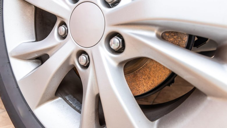 Ржавый налёт на тормозном диске за спицами колеса – знакомая картина после долгой стоянки автомобиля.