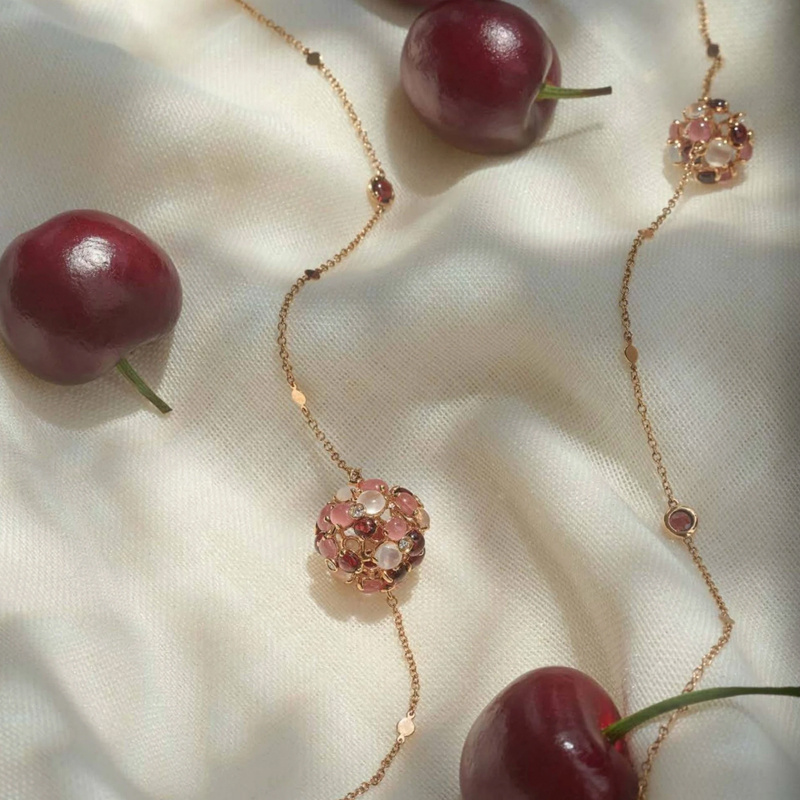 На фото: колье Utopia Cherry Blossom из розового золота с бриллиантами, гранатами, родохрозитами, лунным камнем*
