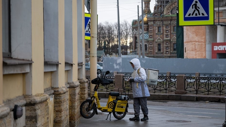    Курьер собрал заказ в Петербурге и составляет маршрут с помощью смартфона. Автор фото: Михаил Тихонов / "Деловой Петербург"