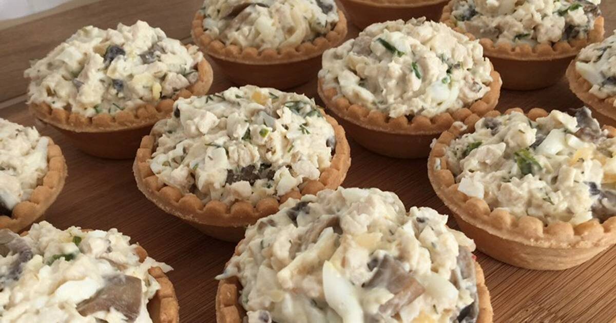 Тарталетки с отварным куриным филе, вареными яйцами и обжаренными шампиньонами с луком - очень вкусная и сытная закуска. Тарталетки с курицей и грибами отлично подойдут для любого праздничного стола.