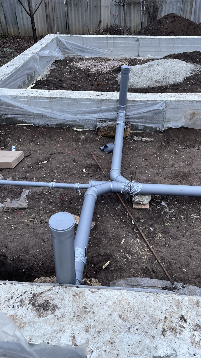 Вместо оранжевых труб установили серые - для внутренних работ. Не закрепили, уложив на камни. Сверху залили плитой.