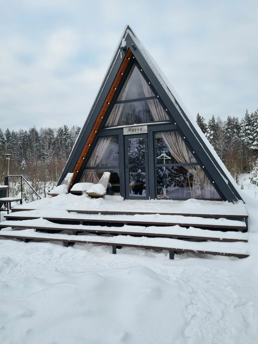 Лаконичный темный фасад контрастирует с белизной леса. Это то самое место, где можно забыть о городской суете, укутаться в плед и просто смотреть, как падает снег за окном