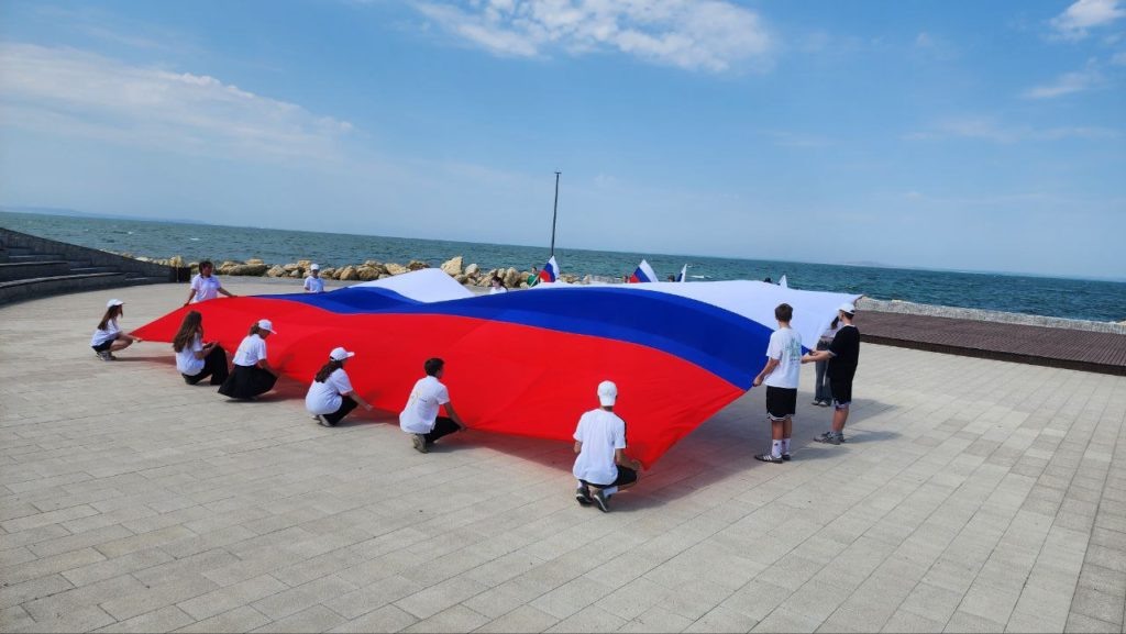    Волонтёры развернули огромный российский триколор на площади Ушакова в Тамани. Фото: Таманское КСЦ.