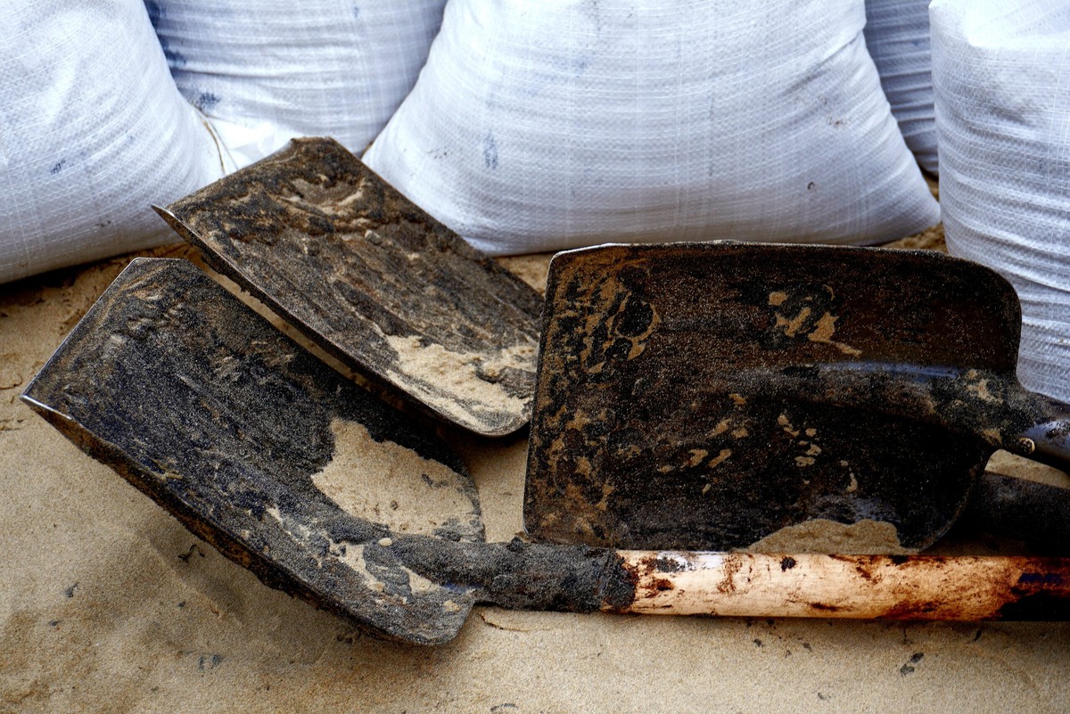    Юрий Михайлович собирает мазут в мешки. Фото: Штаб #МЫВМЕСТЕ