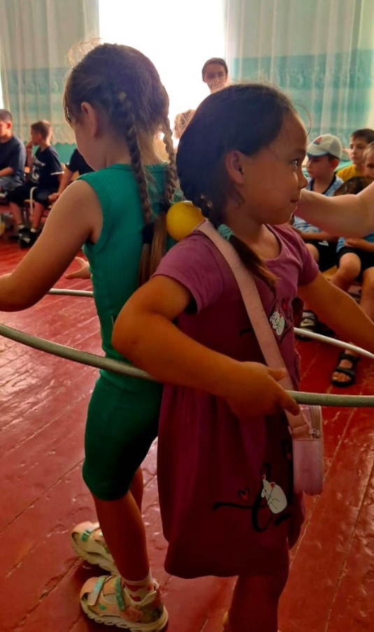 Переносили шарики, зажав их между спинами