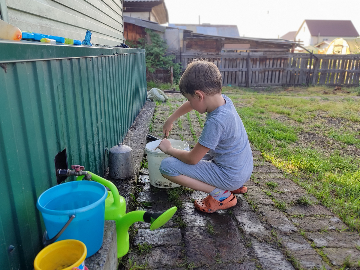 Вадюха что-то в ведре с водой шаманит, пока вода в лейку набирается