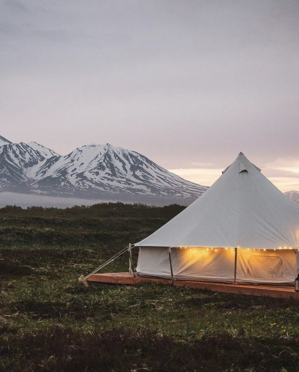 На фотографии глэмпинг “Kamrelax” на берегу Тихого океана с видом на горы и вулканы Камчатки