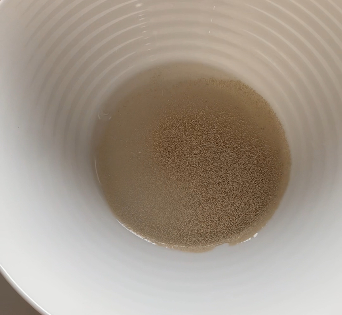 В теплую воду добавить сухие дрожжи.