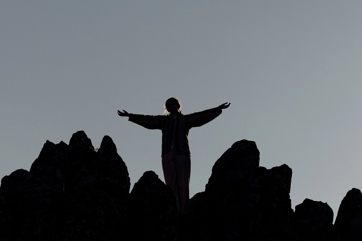   Женщина встречает восход солнца во время летнего солнцестояния на вершине скалистого гребня в «мегалитической обсерватории» Кокино, Северная Македония 
Georgi Licovski / EPA / TASS