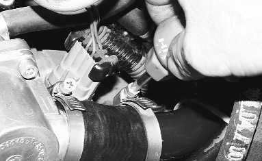 2. Ослабьте затяжку двух хомутов шлангов на патрубках крышки гнезда термостата и…