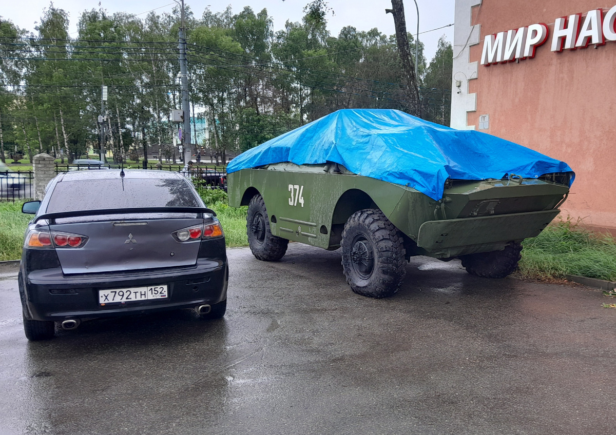 Стоит броневик под тентом, укрытый от дождя!
