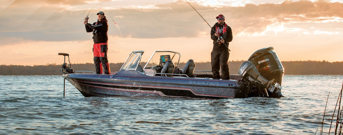 Рыбаки ловят рыбу на современной лодке. На носу электроякорь удерживает лоду на месте. 