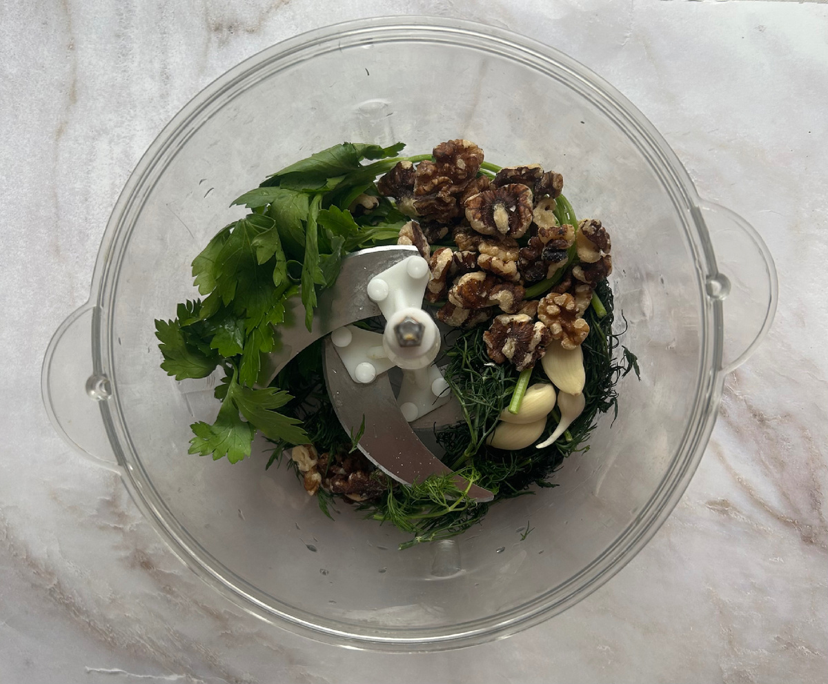 В измельчителе соединить пучок петрушки,кинзы,укропа;чеснок;грецкие орехи и 1 столовую ложку оливкового масла.