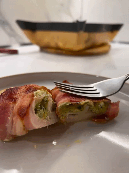 Готовый рулет с начинкой из сыра и шпината, обернутый в сырокопченый поджаренный бекон