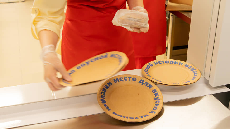 Сотрудница кухни даркстора выкладывает бургер в фирменную тарелку.📷Фото: Егор Снетков / Коммерсантъ