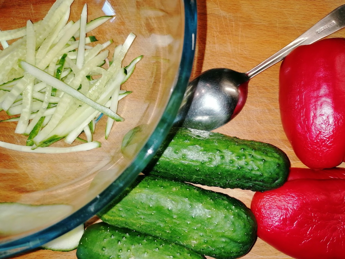 4 огурчика и один не самый крупный перец. Специально положила столовую ложку, чтобы было понятно, какого размера овощи