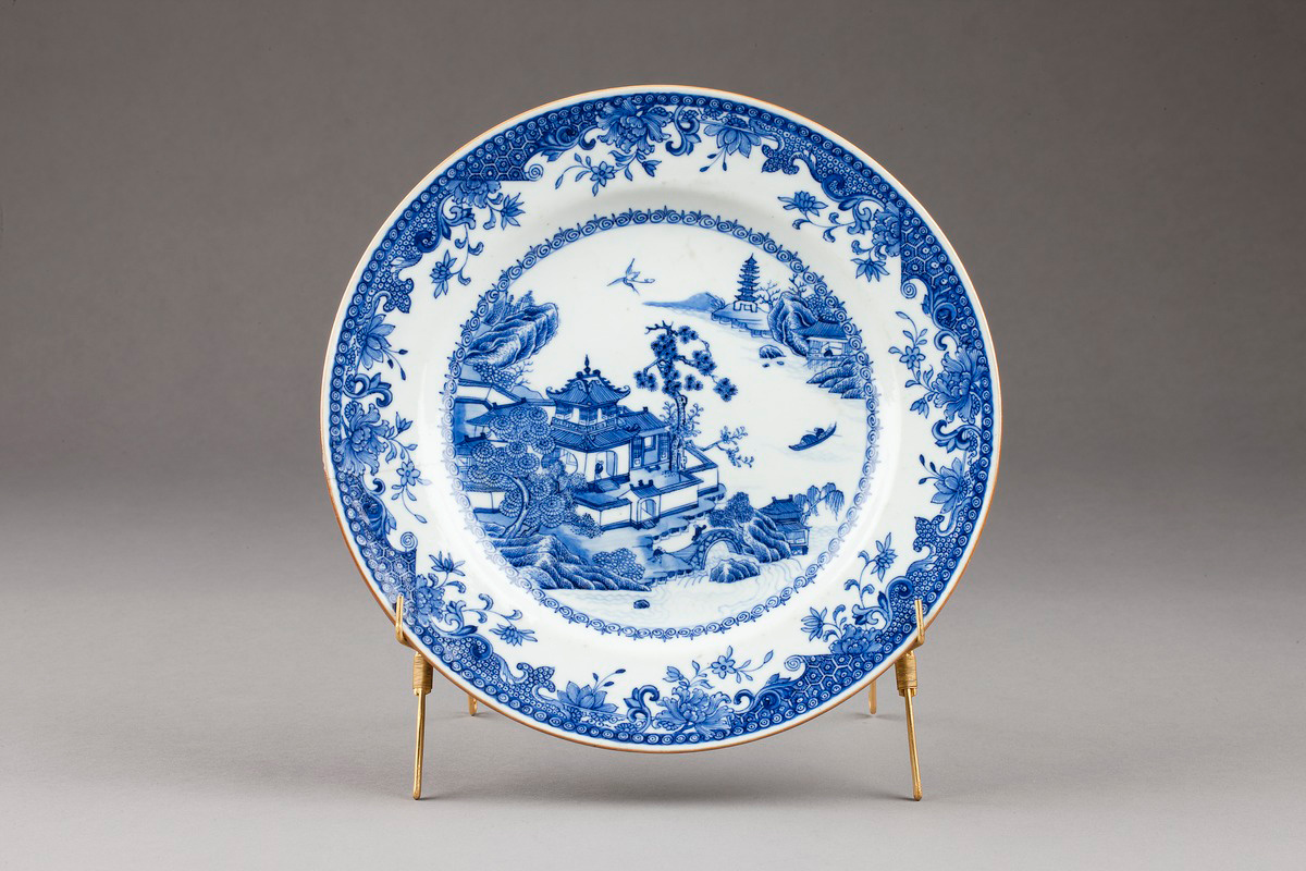 Китайская тарелка с подглазурной синей росписью, около 1770 г. На ней изображён традиционный пейзаж с павильонами у воды – подобные экспортные фарфоровые изделия из Цинской империи вдохновили появление английского узора Blue Willow. (фото: Jens Mohr)