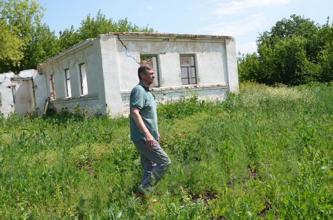 Владимир Курилов когда-то в доме, что на фото за его за спиной, провёл своё детство у бабушки с дедушкой в Падворских Выселках: «Волнительно видеть такое запустение, если помнишь всё цветущим».