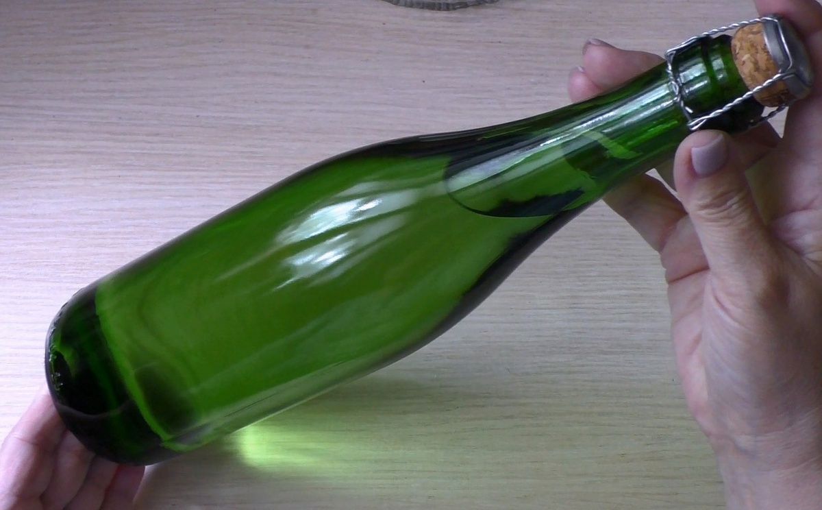 Сегодня я делаю декор бутылки шампанского. Можно использовать и любой другой напиток, все дело вкуса и предпочтений. Сначала необходимо удалить наклейки. Для этого налейте прохладную воду в ведро и опустите туда бутылку по "горлышко". Оставьте на некоторое время, примерно 30 минут.  Наклейки легко удаляются. Хорошо вымойте стекло пищевой содой и моющим средством, просушите.