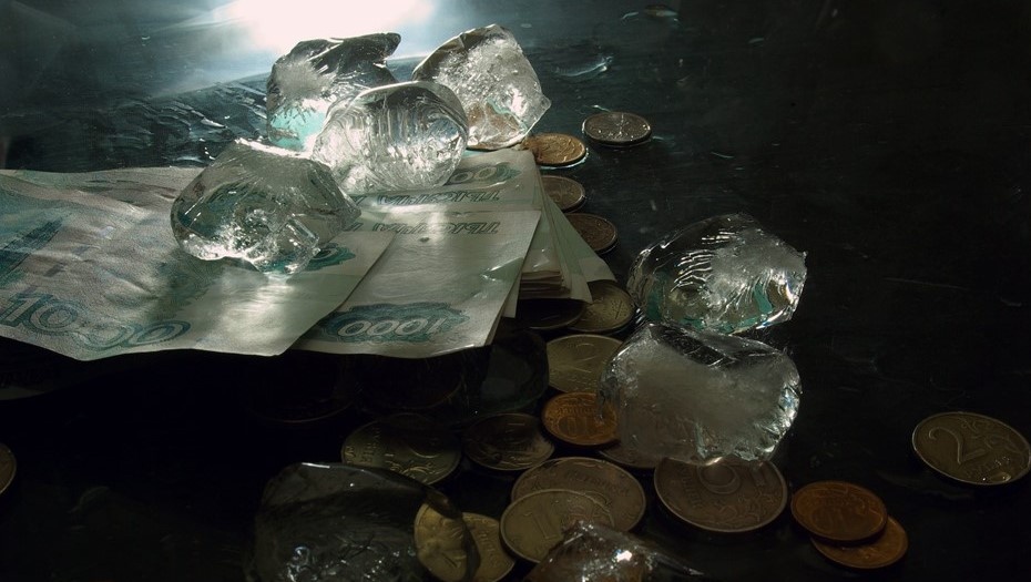    Денежные купюры с монетами и кубики льда на чёрном столе, фото для иллюстрации. Автор фото: Елена Яковлева / "Деловой Петербург"