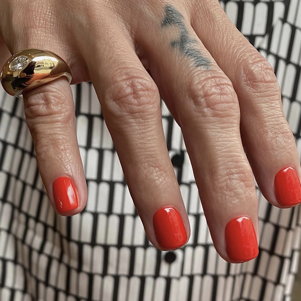 Выбери правильный красный.
Не классический, а с тёплым томатным подтоном — как у спелого черри на солнце. Такой цвет работает сам по себе, особенно на короткой длине с идеальным глянцем.
