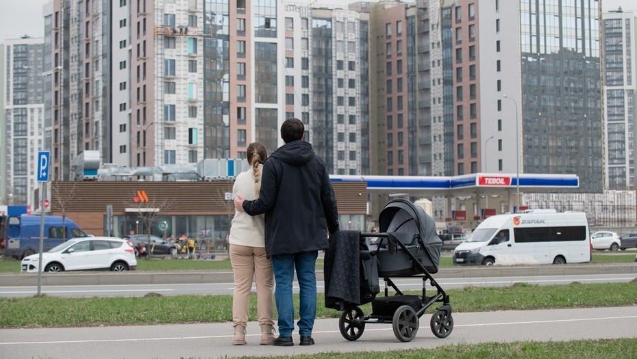    Молодая семейная пара рассматривает новостройки в Приморском районе Петербурга во время прогулки с новорождённым ребёнком. Автор фото: Сергей Ермохин / "Деловой Петербург"