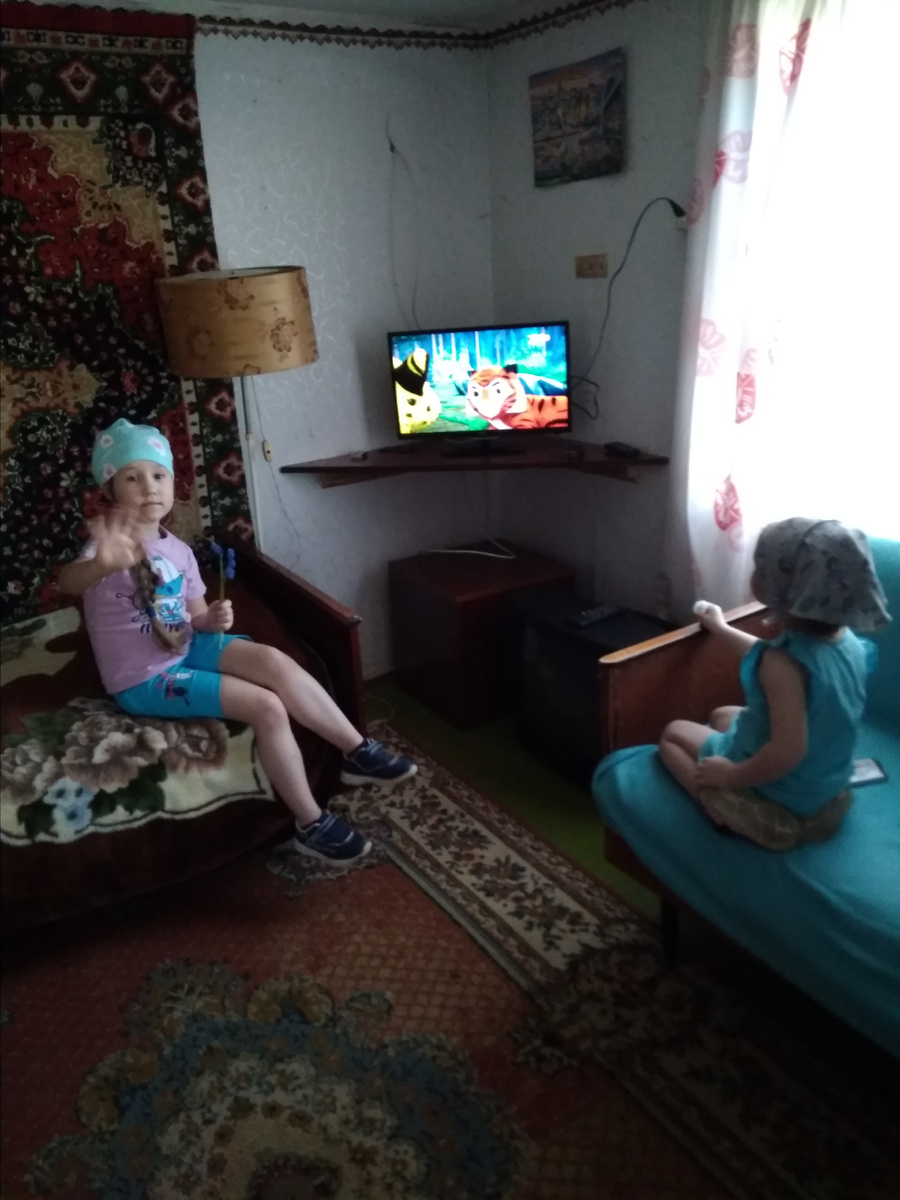 Комната на первом этаже до ремонта. Дочки смотрят телевизор. 