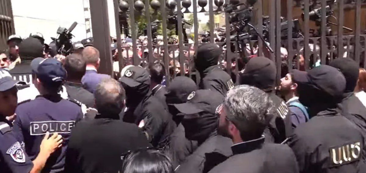 Полиция в масках пытается прорваться к священникам. Прихожане пока держатся. Скриншот. 