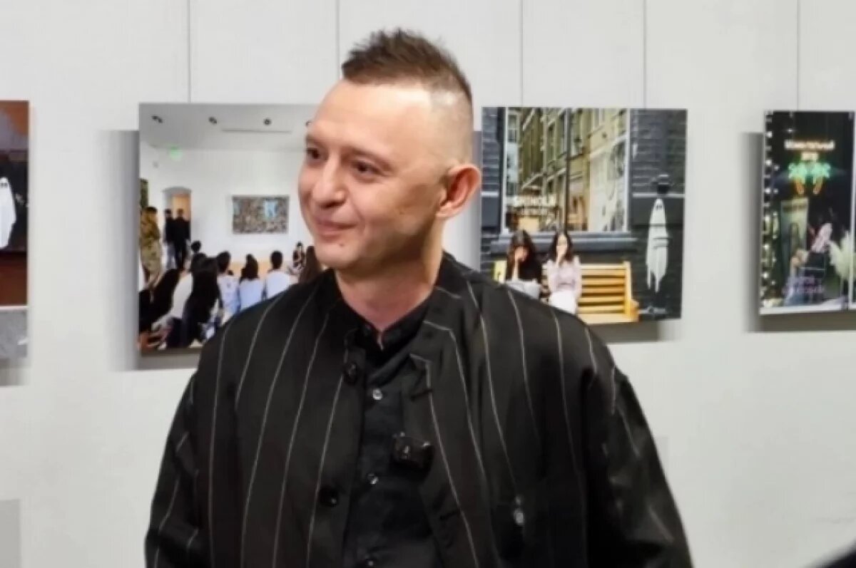    Роман «Зверь» дает интервью напротив своих работ.