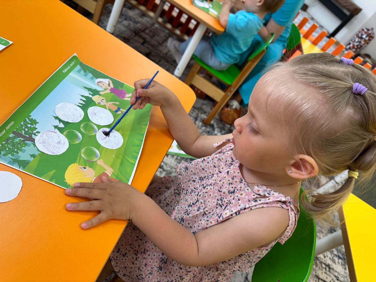 Екатерина на занятии в детском центре рисует 