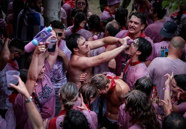 Местные жители обливают друг друга примерно 50 000 литров вина в течение однодневного мероприятия. Марта Монтана Гомес/Reuters.