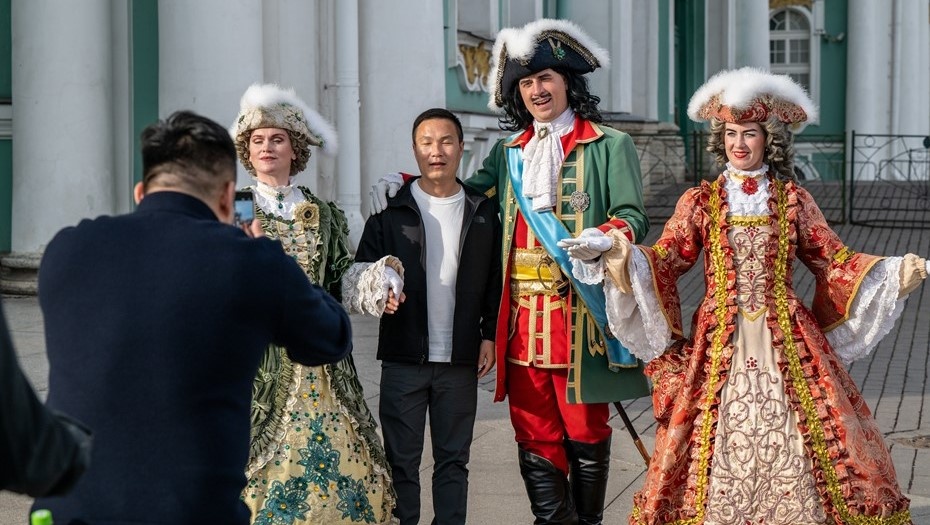    Аниматоры в костюмах Петра Первого и российских цариц окружили азиатского туриста. Автор фото: Тихонов Михаил/ДП
