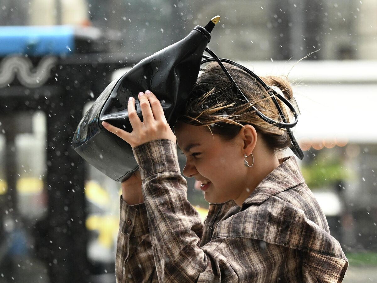    Девушка закрывается от воды сумкой во время ливня в Москве© РИА Новости / Пелагия Тихонова