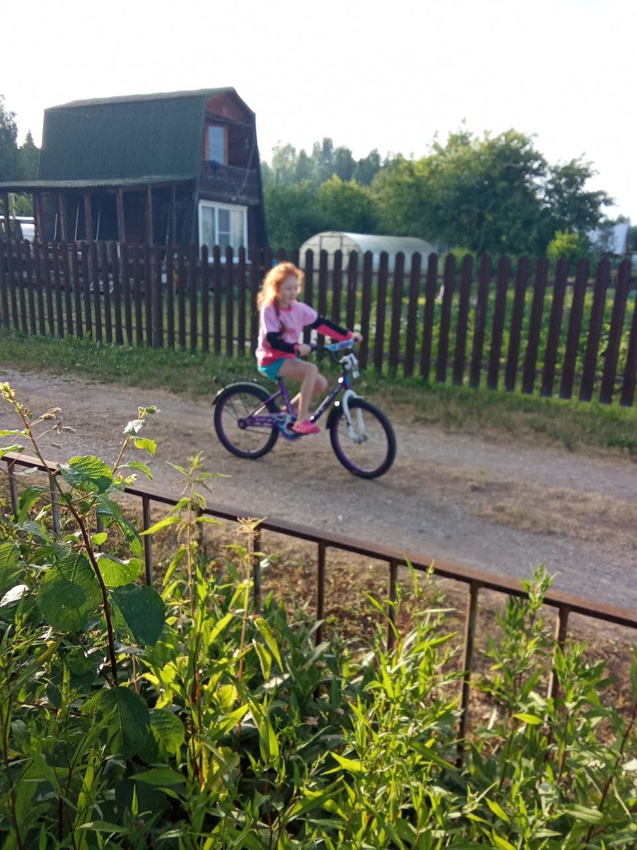 Дочка катается на велосипеде       