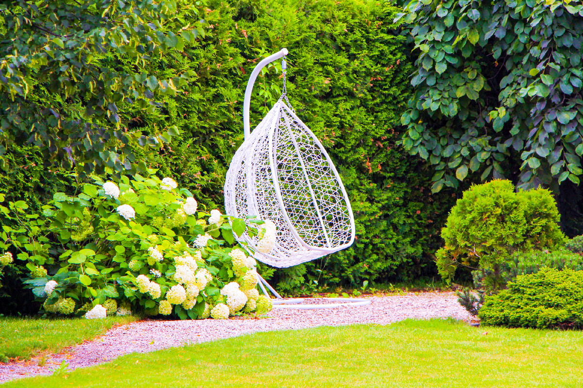 Подвесное кресло на площадке для отдыха в саду