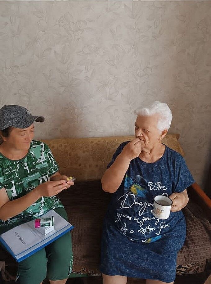 Социальная работница принесла лекарства пожилой женщине