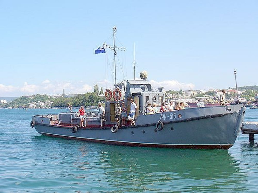 Фотоиллюстрация из открытой сети Интернет: Рейдовый катер «РК-516». Севастополь. Лето 2015 года. За кормой катера на берегу видны белые домики и причал той самой Аполлоновой бухты – севастопольского гриновского Лисса. Это тот самый катер, за штурвалом которого я и мои товарищи, курсанты-слушатели Севастопольской Морской школы ДОСААФ 29 мая 1971 года сдавали первую в моей жизни "курсовую задачу на море".