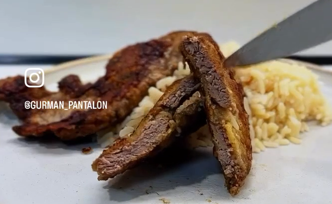 Готовый обжаренный шницель, поданный порции риса.