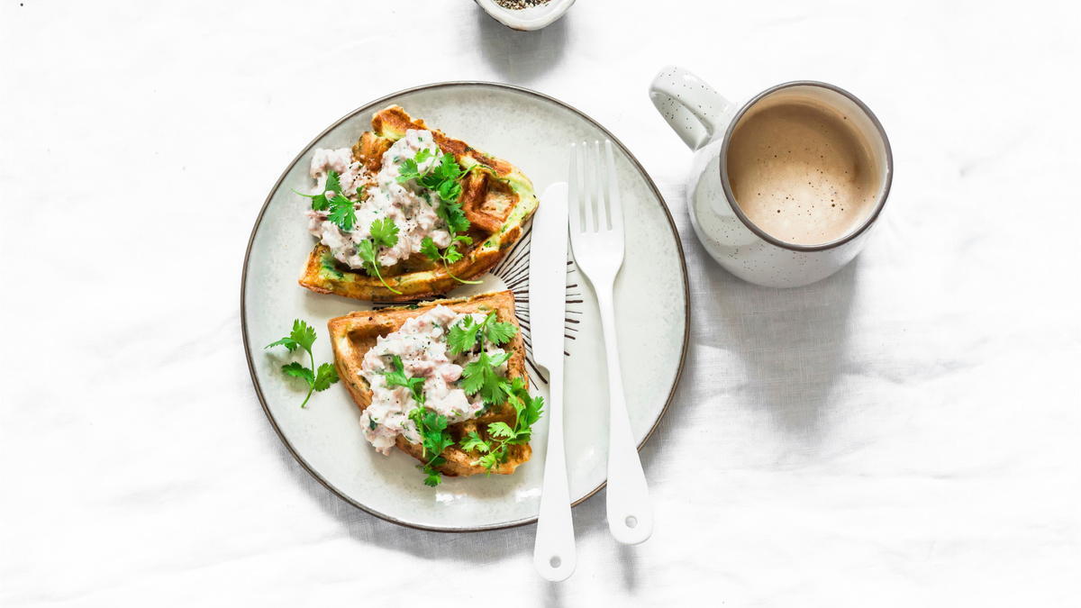 Вафли из кабачков с пармезаном золотистого цвета, поданы с тунцом и сливочным сыром.