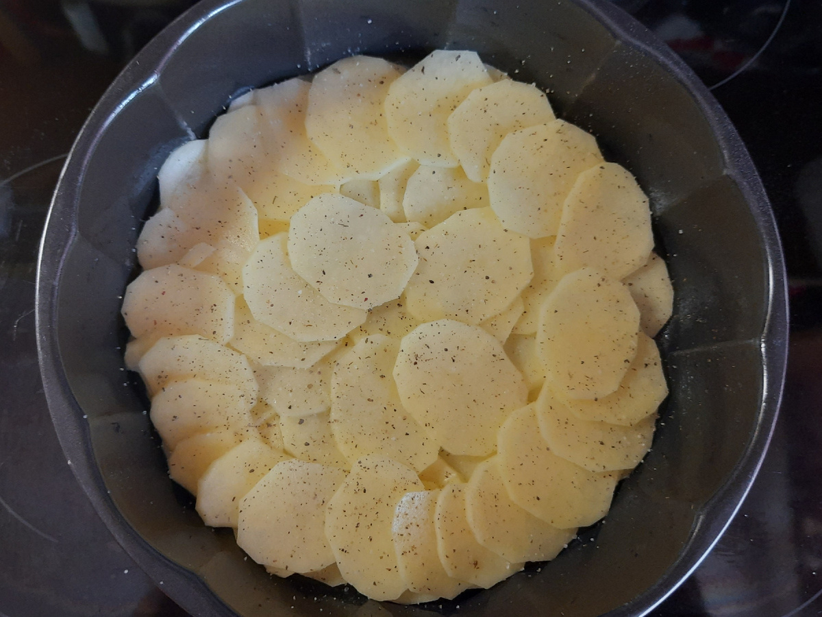 Выложить в форму половину картофеля, посолить и поперчить. Фото автора.