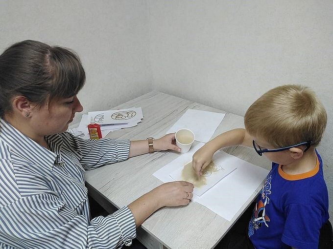 Першина Вероника Вячеславовна показывает мальчику как рисовать руками на песке