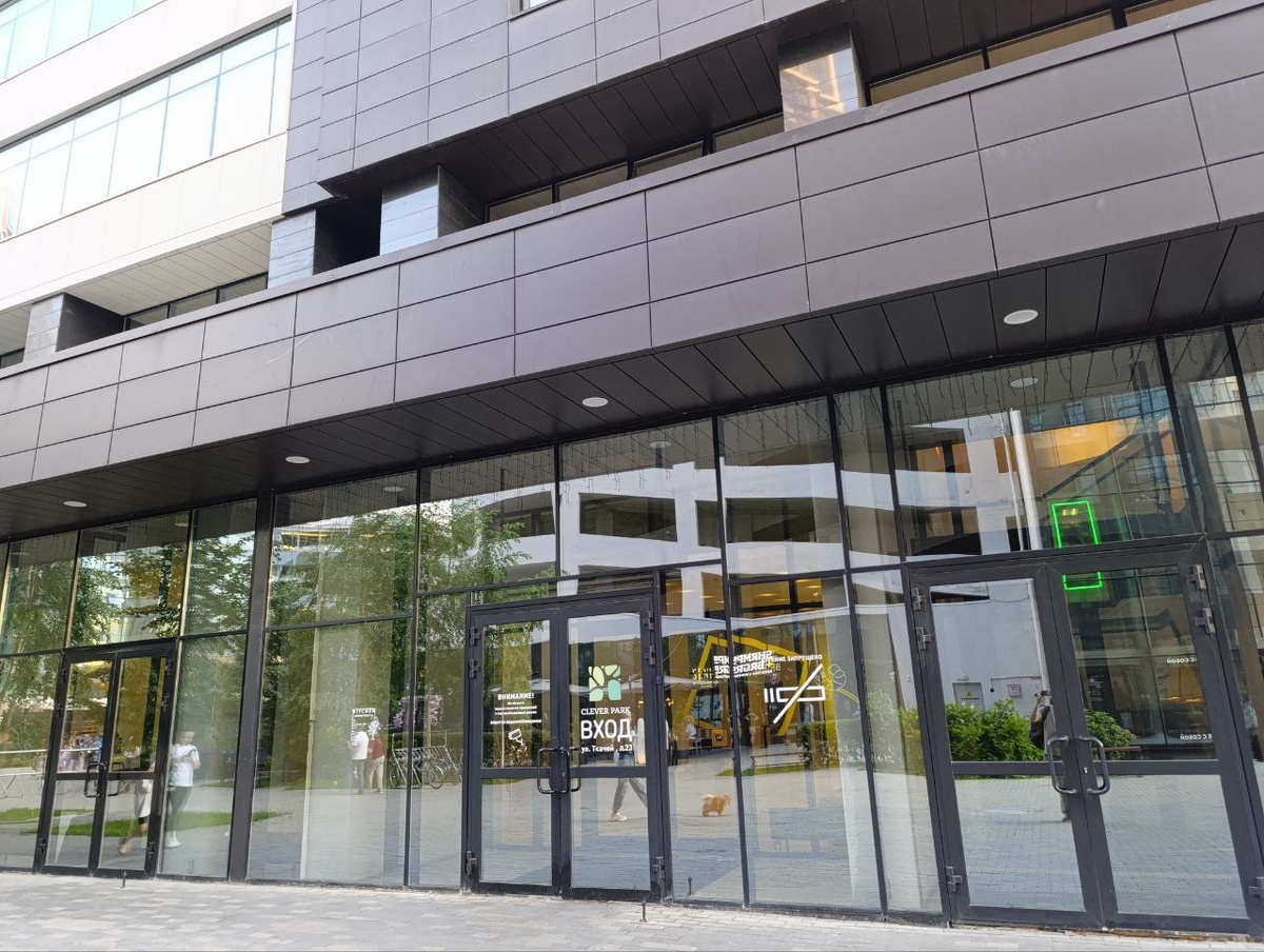 Вот в эту дверь с надписью "Вход" нужно зайти, если хотите найти ресторан Kitchen. Надпись о том, что он тут находится, ровно в том месте, где в стекле отражаются люди в красной и белой футболках.